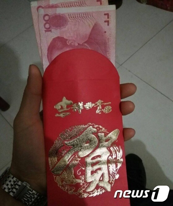 류씨가 은행으로부터 받은 감사 선물. 200위안이 붉은 봉투에 담겨 있다. (웨이보 갈무리) © News1