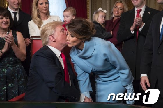 [사진] 트럼프, 아내에 키스…인준안 '첫서명'