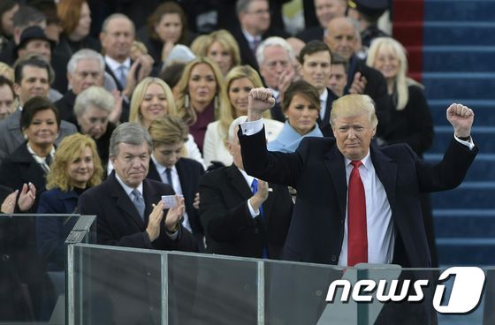 20일(현지시간) 제45대 미국 대통령으로 취임한 도널드 트럼프(왼쪽)가 워싱턴DC 국회의사당 앞에서 펼쳐진 취임식 도중 두 주먹을 번쩍 들어 올리고 있다. © AFP=뉴스1 © News1 김혜지 기자