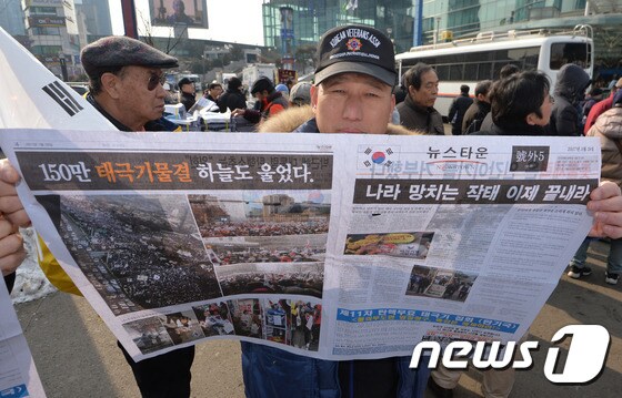 '탄핵기각' 신문 든 보수단체 회원