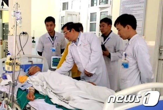 베트남 보건당국자들이 배에서 가위를 무사 제거한 남성을 병문안하고 있다. (현지 매체 갈무리) © News1