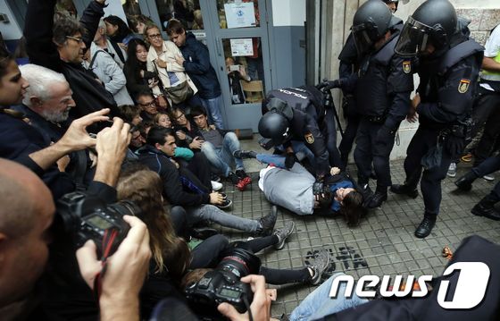 독립투표장에서 주민을 끌어내는 스페인 경찰. © AFP=뉴스1