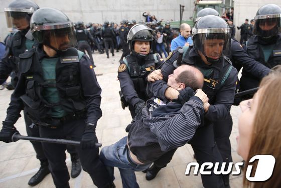 스페인 경찰이 중앙정부와 법원에 의해 위헌으로 규정된 카탈루냐 자치정부 분리·독립 투표소에서 주민들을 끌어내고 있다. © AFP=뉴스1
