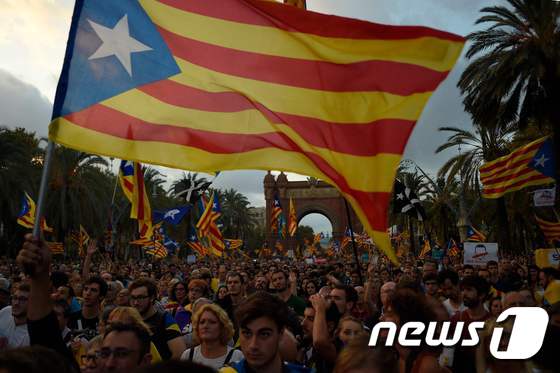 카탈루냐 분리독립을 주장하는 주민들이 10일(현지시간) 카를로스 푸지데몬 수반의 일시 중지 선언을 시청하며 불만스러운 표정을 짓고 있다. © AFP=뉴스1