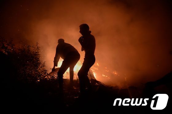 소방 당국과 지역 주민이 스페인 북서부 산불을 진화 중이다. © AFP=뉴스1