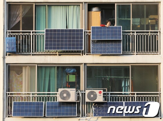 24일 오후 서울 노원구의 한 아파트 단지에서 한 입주민이 베란다에 설치된 태양광 판넬을 살펴보고 있다. 2017.10.24/뉴스1 © News1 이재명 기자