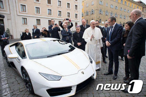 프란치스코 교황이 15일(현지시간) 슈퍼카를 선물로 받은 뒤 람보르기니 최고경영자(CEO) 스테파노 도메니칼리와 얘기를 하고 있다. © AFP=뉴스1