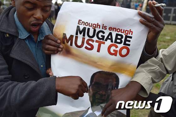 한 짐바브웨 남성이 수도 하라레에서 무가베 퇴진을 촉구하는 포스터를 들고 있다. 포스터에 쓰인 글은 