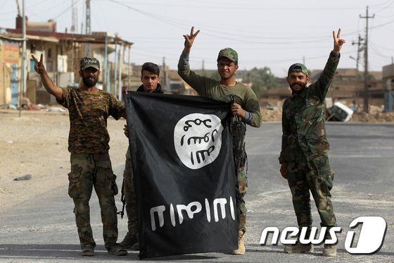 이라크 시아파 민병대가 알카임 마을에서 IS 깃발을 내보이고 있다. (자료사진) © AFP=뉴스1
