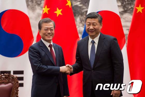 문재인 대통령과 시진핑 중국 국가주석이 지난 14일 오후 베이징 인민대회당 서대청에서 열린 MOU 서명식을 마치고 악수하고 있다. © AFP=뉴스1