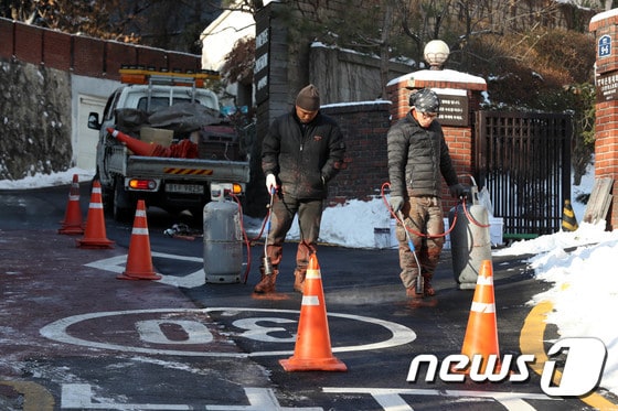 2017년 서울 성북구의 한 이면도로에서 성북구 관계자들이 낙상 사고 예방을 위해 얼음을 녹이는 모습. © News1 박세연 기자
