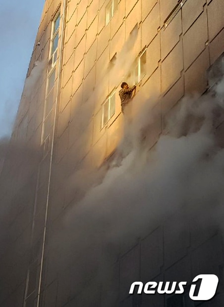21일 오후 3시53분쯤 충북 제천시 하소동의 8층짜리 사우나 건물에서 불이 나 구조를 기다리던 시민이 건물 외벽에 매달려 있다. (독자 제공) 2017.12.21/뉴스1 © News1 조영석 기자