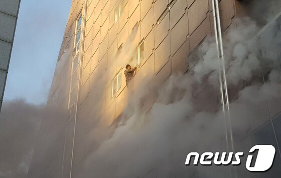 21일 오후 3시53분쯤 충북 제천시 하소동의 8층짜리 스포츠센터에서 불이 나 구조를 기다리던 시민이 건물 외벽에 매달려 있다. 화재로 29명이 사망했다.(독자 제공) 2017.12.21/뉴스1 © News1 조영석 기자