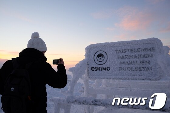 눈으로 뒤덮인 표지판을 사진 찍고 있는 여행객의 모습© News1 윤슬빈 기자