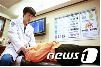 자생한방병원 의료진이 목 통증 환자에게 추나요법을 실시하고 있다.© News1