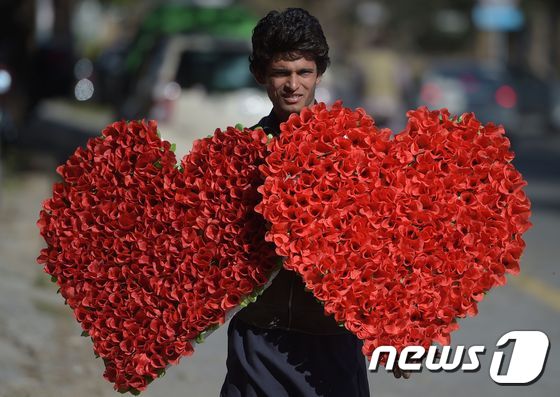파키스탄 이슬라마바드. 길거리에서 한 상인이 하트 모양의 장미 부케를 팔고 있다.© AFP=뉴스1