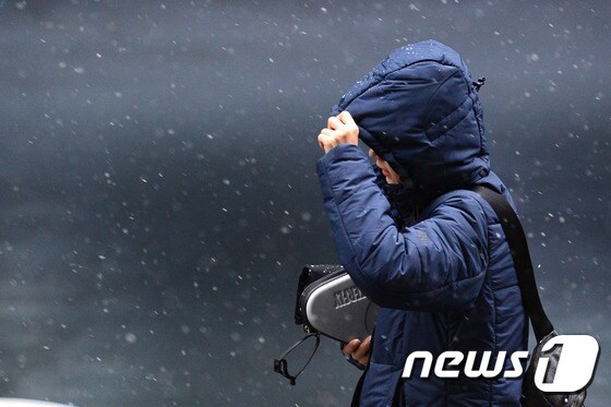 눈이 내린 22일 오전 서울 강남구 대치동 인근에서 한 시민이 내리는 눈을 맞으며 발걸음을 재촉하고 있다. 2017.2.22/뉴스1 © News1 임세영 기자