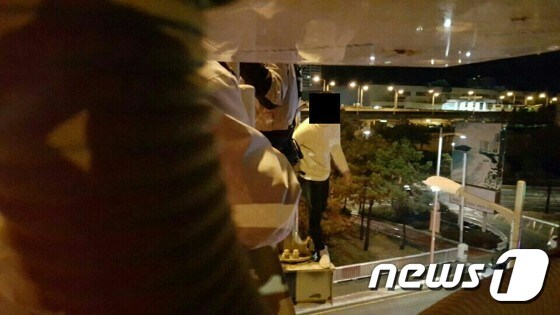 23일 오전 2시 2분께 부산 광안대교 하판 난간 위에 서있던 20대 남성을 상대로 경찰관이 설득을 벌이고 있다.(부산지방경찰청 제공)© News1