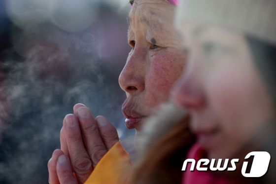 <br />몽골 수도 울란바토르에서 한 여인이 영하 20도에 이르는 강추위에에 입김으로 손을 녹이고 있다.  © AFP=뉴스1