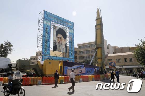 이란 탄도미사일 '가드르'가 아야톨라 알리 하메네이 이란 최고지도자 초상과 함께 테헤란 광장에 세워져 있다. © AFP=뉴스1