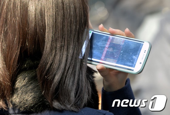 스마트폰을 이용해 동영상을 감상하고 있는 시민의 모습/뉴스1 © News1
