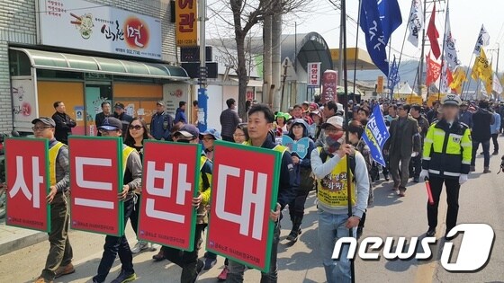 경북 성주군 초전면에서 열린 '평화발걸음' 행진대회 참가자들이 '사드반대' 등의 피켓을 들고 사드배치지인 소성리 마을로 행진을 벌이고 있다. © News1