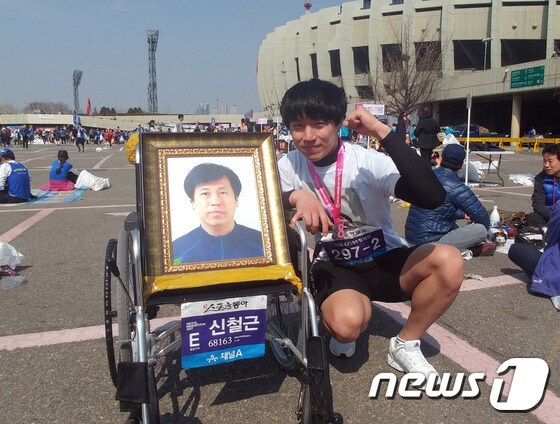19일 오후 돌아가신 아버지의 영정사진과 함께 마라톤 대회를 마친 신경하씨(24)© News1