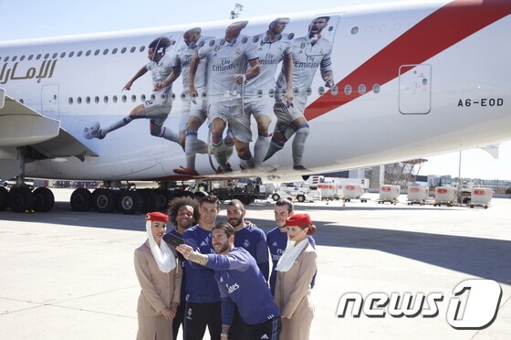 에미레이트 항공사 승무원들과 기념 사진을 찍고 있는 레알 마드리드 선수단© News1