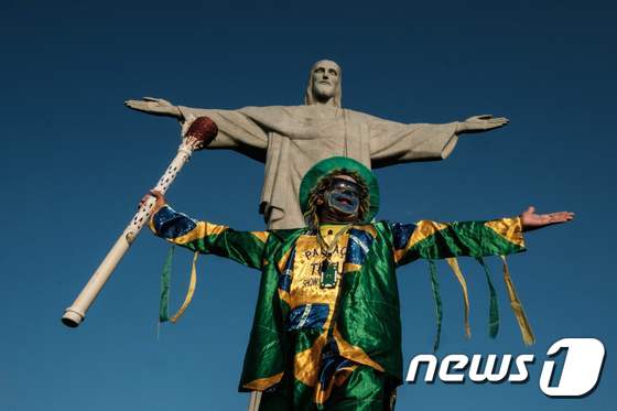 브라질 리우데자네이루 예수상 앞에서 브라질을 상징하는 색깔의 옷을 입은 사람. © AFP=뉴스1