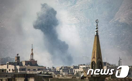 24일(현지시간) 시리아 수도 다마스쿠스 동쪽 외곽 반군 점령지역 요바르에서 공습으로 인한 검은 연기가 치솟고 있다. © AFP=뉴스1