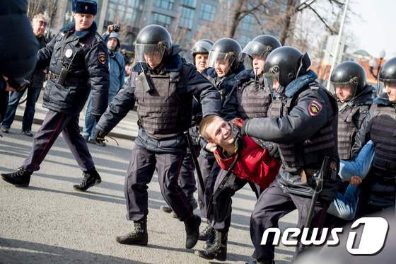 러시아 경찰이 26일(현지시간) 모스크바에서 열린 반부패 시위에 참가한 시민을 체포했다. © AFP=뉴스1