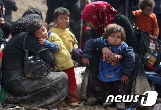 24일(현지시간) 이라크 모술에서 전쟁을 피해 나온 피난민들이 길 위에서 휴식을 취하고 있다. © AFP=뉴스1