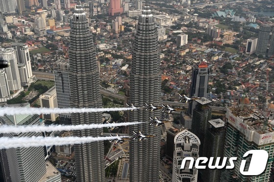 29일 대한민국 공군의 특수비행팀 블랙이글스가 말레이시아 쿠알라룸푸르의 랜드마크인 페트로나스 트윈타워를 배경으로 공중기동을 선보이고 있다. (공군 제공) 2017.3.29/뉴스1