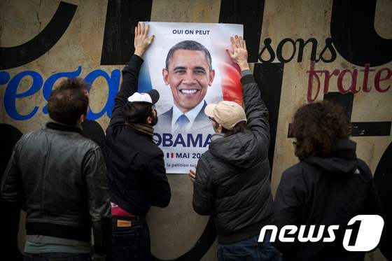 버락 오바마 전 미국 대통령의 프랑스 대선 출마를 바라는 프랑스인들이 그의 포스터를 붙이고 있다. © AFP=뉴스1