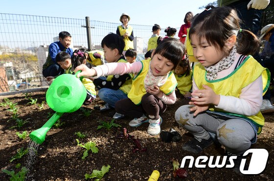 12일 오후 서울 종로구 무악동 도시텃밭에서 열린 개장식에 참석한 어린이집 원생들이 모종에 물을 주고 있다. 2017.4.12/뉴스1 © News1 신웅수 기자
