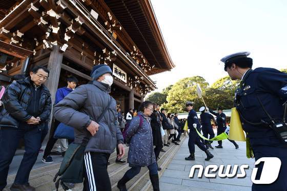 일본 경찰(오른쪽)이 지난 1월1일 도쿄 메이지신궁을 찾은 시민들을 통제하고 있다. © AFP=뉴스1