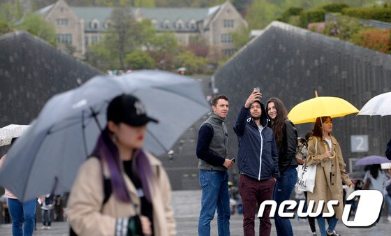 봄비가 내리는 17일 오후 서울 서대문구 이화여대 교정에서 외국인들이 스마트폰 셀카를 찍고 있다./뉴스1 © News1 안은나 기자