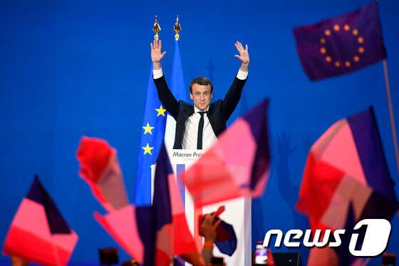 23일(현지시간) 프랑스 중도 성향 '앙마르슈!'(전진)의 에마뉘엘 마크롱 대선 후보가 결선투표 진출이 확실시되자 두 팔을 들고 지지자들에게 인사하고 있다. © AFP=뉴스1