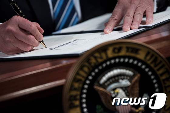 도널드 트럼프 미 대통령이 서명하는 모습. © AFP=뉴스1