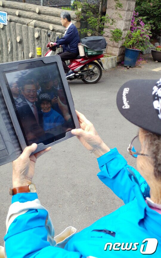11일 오전 서울 서대문구 문재인 대통령 자택 앞에서 대통령과 함께 사진을 찍은 김중길씨(83·여)가 자신이 찍은 사진을 보며 기뻐하고 있다. © News1 박동해 기자