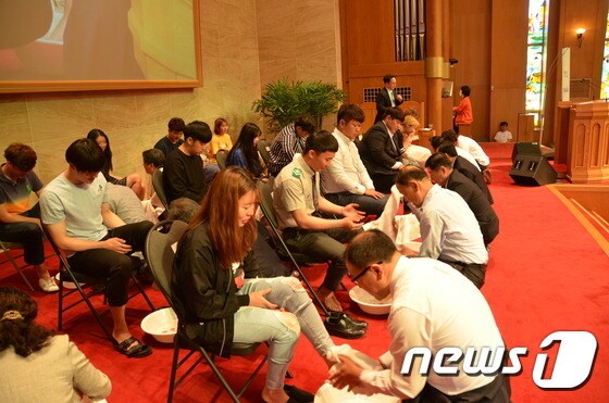 김은기 총장을 비롯한 교수진들이 학생들의 발을 직접 닦아주고 있다.© News1