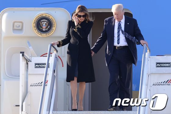 23일(현지시간) 이탈리아 로마 피우미치노 공항에 도착한 도널드 트럼프 대통령이 전용기 계단을 내려가기 전 부인 멜라니아 여사에게 손을 건넸지만, 멜라니아 여사는 머리를 쓸어넘기고 있다.  © AFP=뉴스1