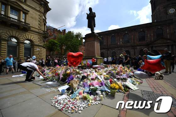 24일(현지시간) 영국 북부 맨체스터 시내 광장에서 시민들이 테러 희생자를 추모하고 있다. © AFP=뉴스1