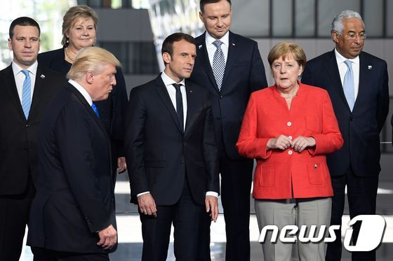 앙겔라 메르켈 독일 총리(오른쪽 2번째)와 에마뉘엘 마크롱 프랑스 대통령이 지난 25일 (현지시간) 브뤼셀의 나토 새 본부 준공식에 도착하는 도널드 트럼프 미국 대통령을 보며 얘기를 나누고 있다. © AFP=뉴스1