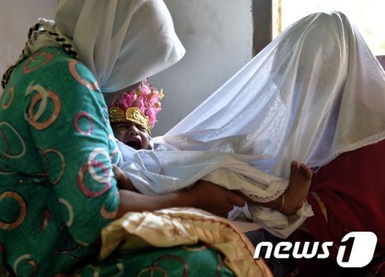지난 2월20일(현지시간) 인도네시아의 고론탈로 주에서 한 여아가 할례 시술을 받고 울음을 터뜨리고 있다. © AFP=뉴스1