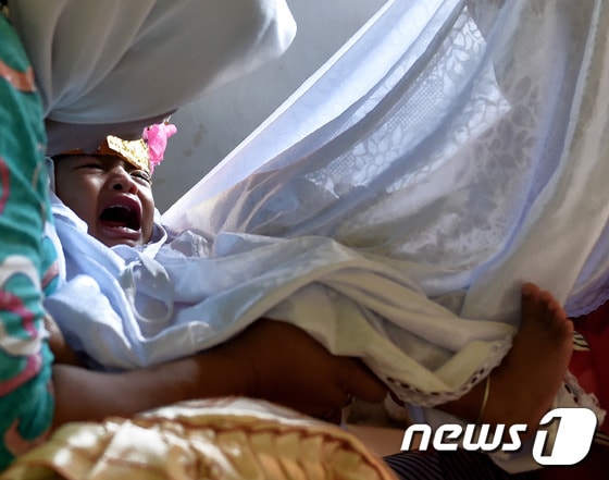 지난 2월20일(현지시간) 인도네시아의 고론탈로 주에서 한 여아가 할례 시술을 받고 울음을 터뜨리고 있다. © AFP=뉴스1