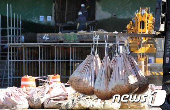 코리아 쌀베지 작업자들이 26일 오후 전남 목포신항에 거치된 세월호에서 나온 펄을 나르고 있다. 2017.5.26/뉴스1 © News1 남성진 기자