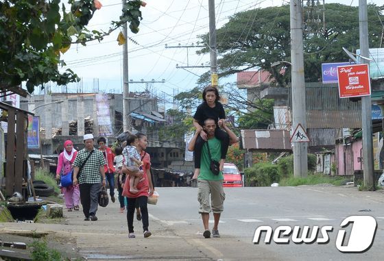 27일(현지시간) 필리핀 남부 민다나오 섬 말라위 지역 주민들이 계엄령이 선포되자 피난하고 있다. © AFP=뉴스1