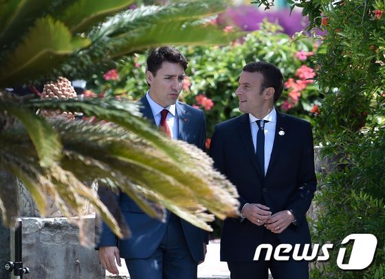 26일(현지시간) 저스틴 트뤼도 캐나다 총리(왼쪽)와 에마뉘엘 마크롱 프랑스 대통령(오른쪽)이 G7 정상회의가 열린 이탈리아 시칠리아 섬에서 만나 이야기를 나누고 있다. © AFP=뉴스1