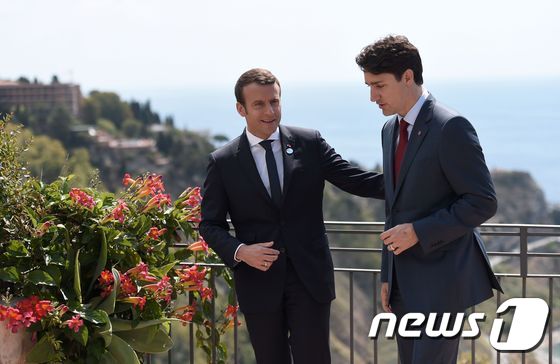 26일(현지시간) 저스틴 트뤼도 캐나다 총리(오른쪽)와 에마뉘엘 마크롱 프랑스 대통령(왼쪽)이 G7 정상회의가 열린 이탈리아 시칠리아 섬에서 이야기를 나누고 있다. © AFP=뉴스1